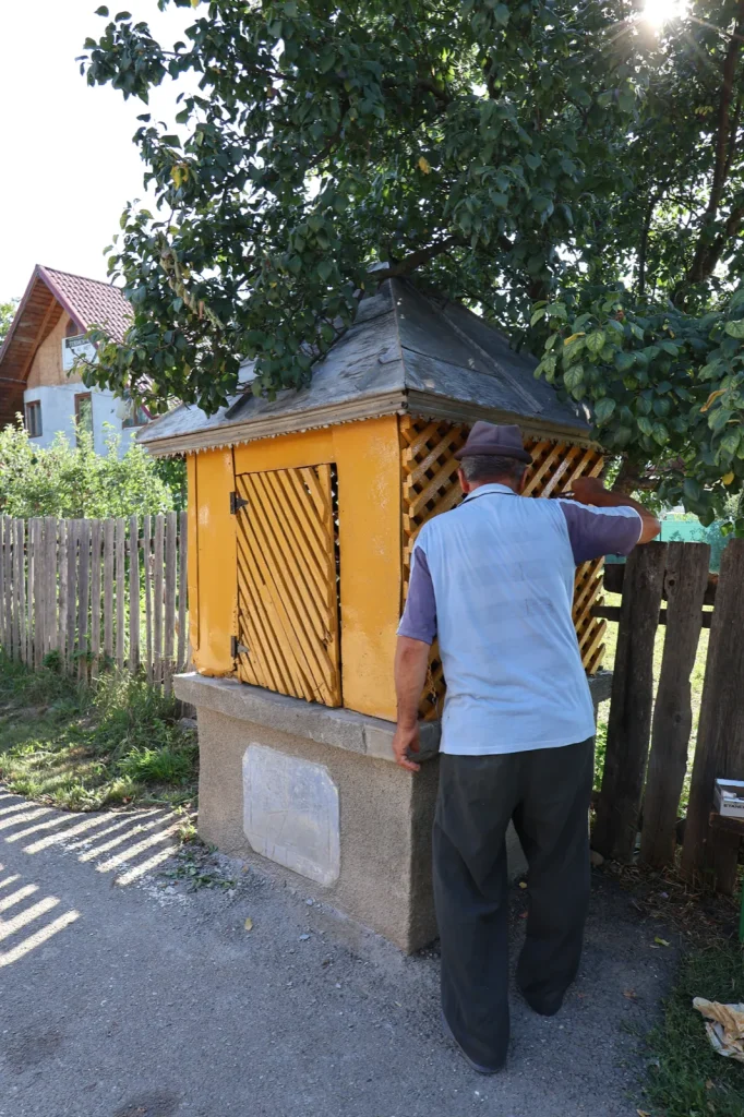 Sătean scoțând apă la Fântâna de poveste din satul Rotunda